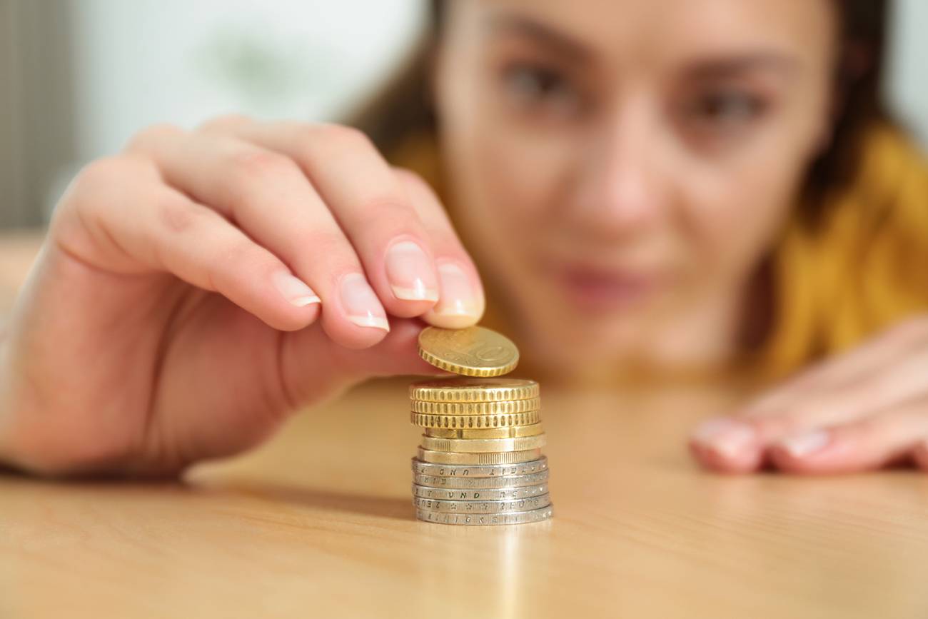 Closeup,View,Of,Woman,Stacking,Coins,At,Table,,Focus,On
